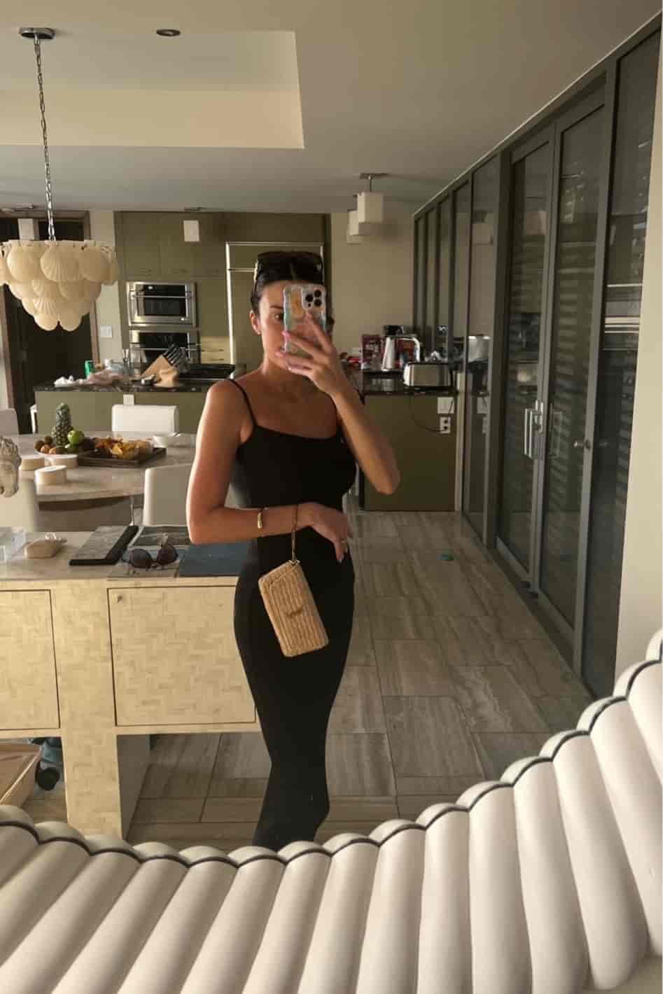 Christine Andrew in a black skims dress on vacation